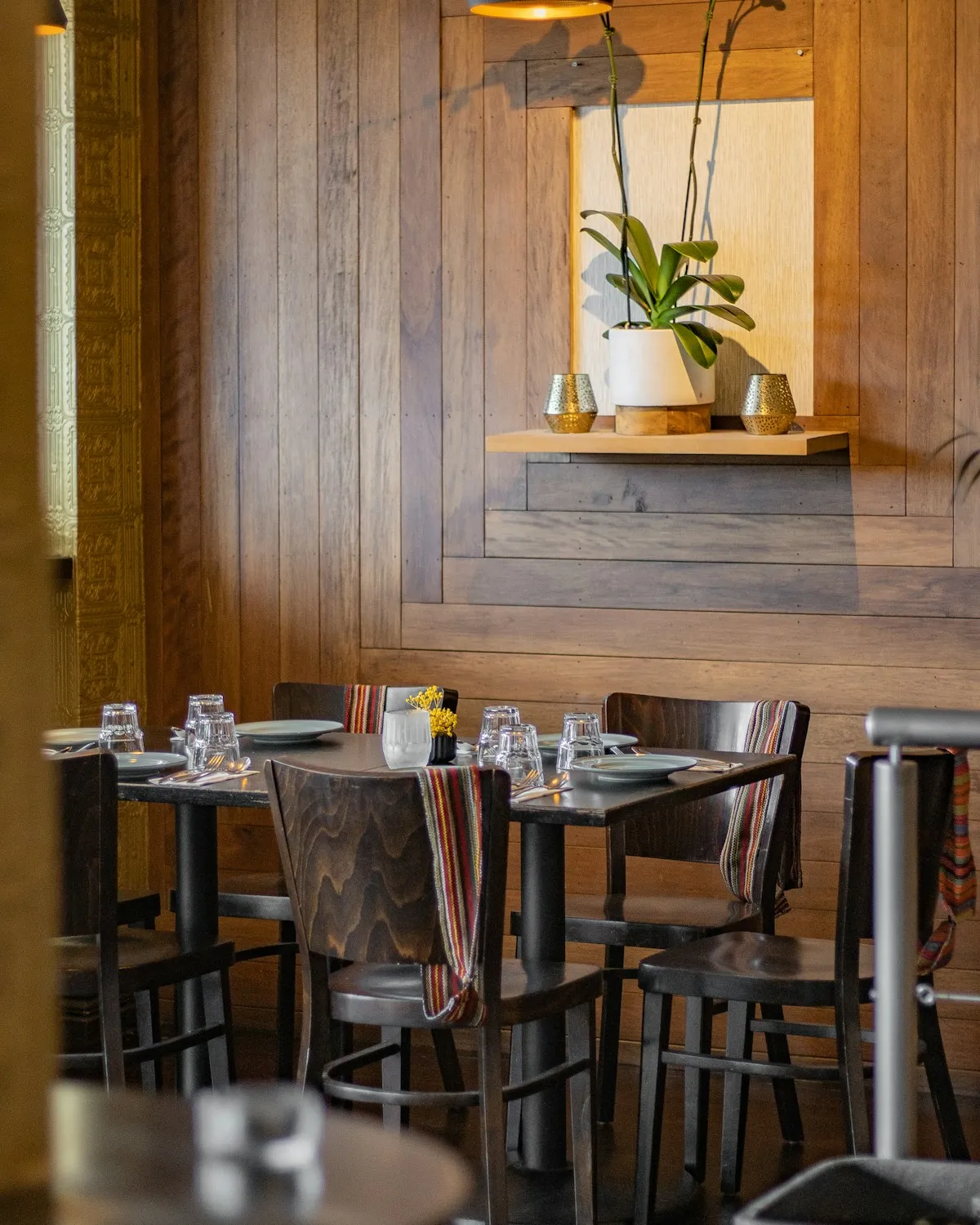 Wood-paneled dining room with a set table and a small potted plant