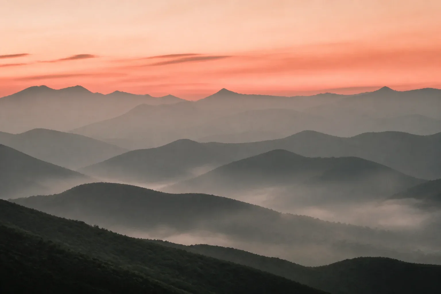Layered mountains beneath a warm sky