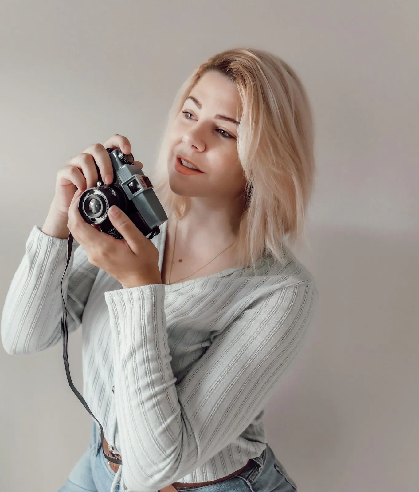 Maren holding a vintage film camera near her face