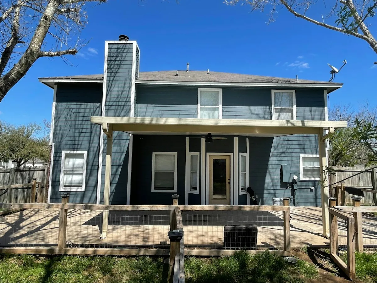 Two-story house with new blue siding and a covered wood porch