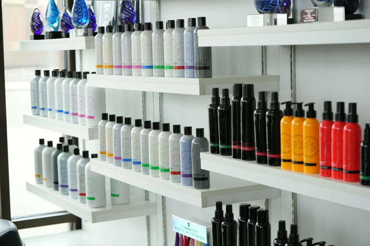 Shelves of colorful hair care products along a salon wall